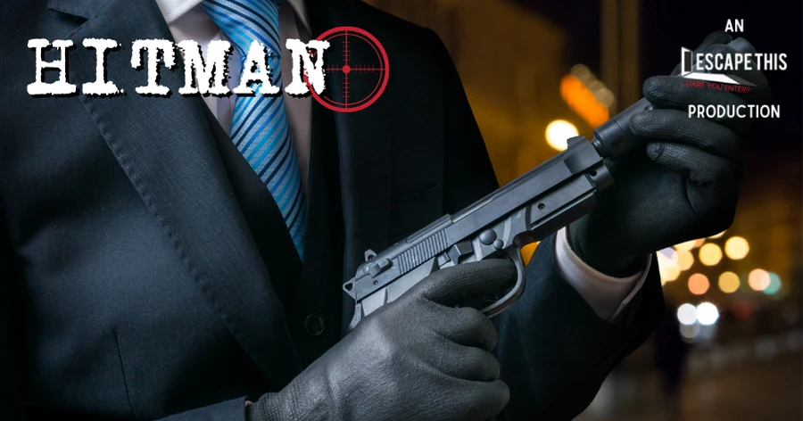 Hitman Escape Room - an Escape This Production. A closeup of a man in a suit's gloved hands attaching a silencer to a pistol.