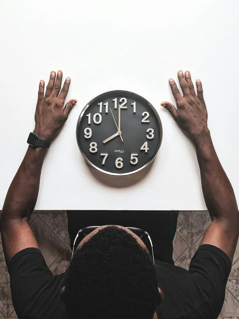 A man sitting in front of a clock